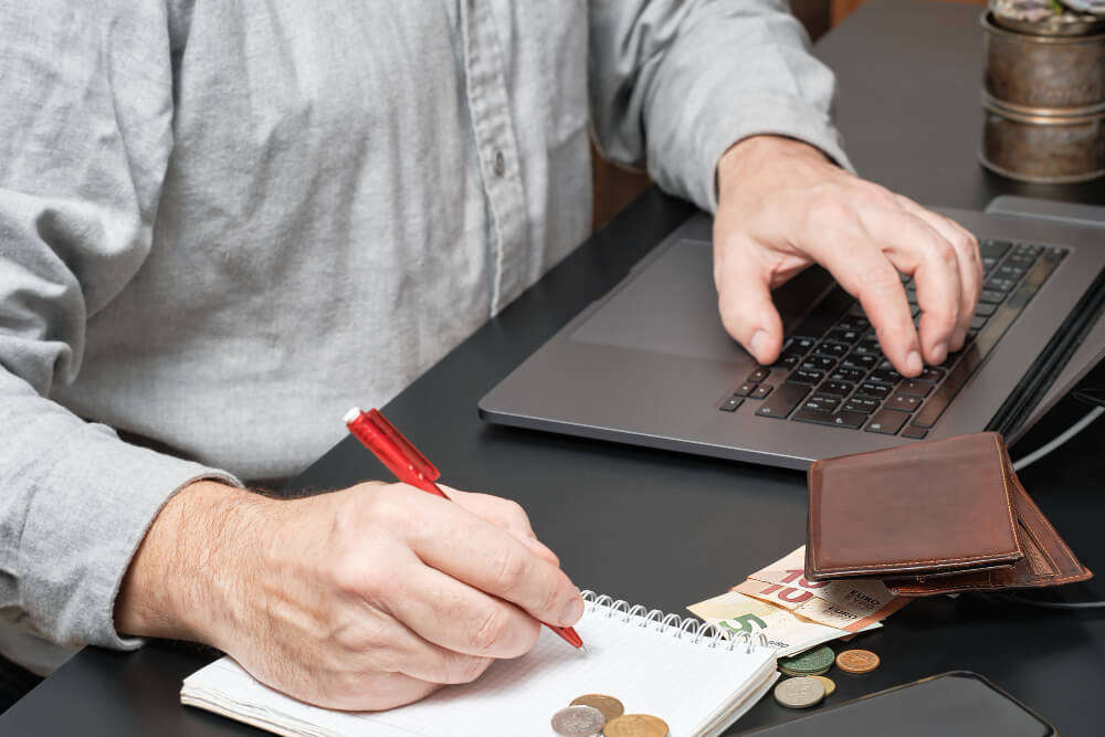 businessman-accountant-holding-pen-working-desk-using-laptop-calculate-financial-report-1